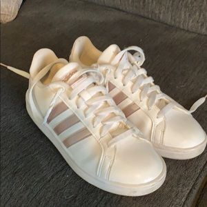 White and rose gold Adidas tennis shoes.